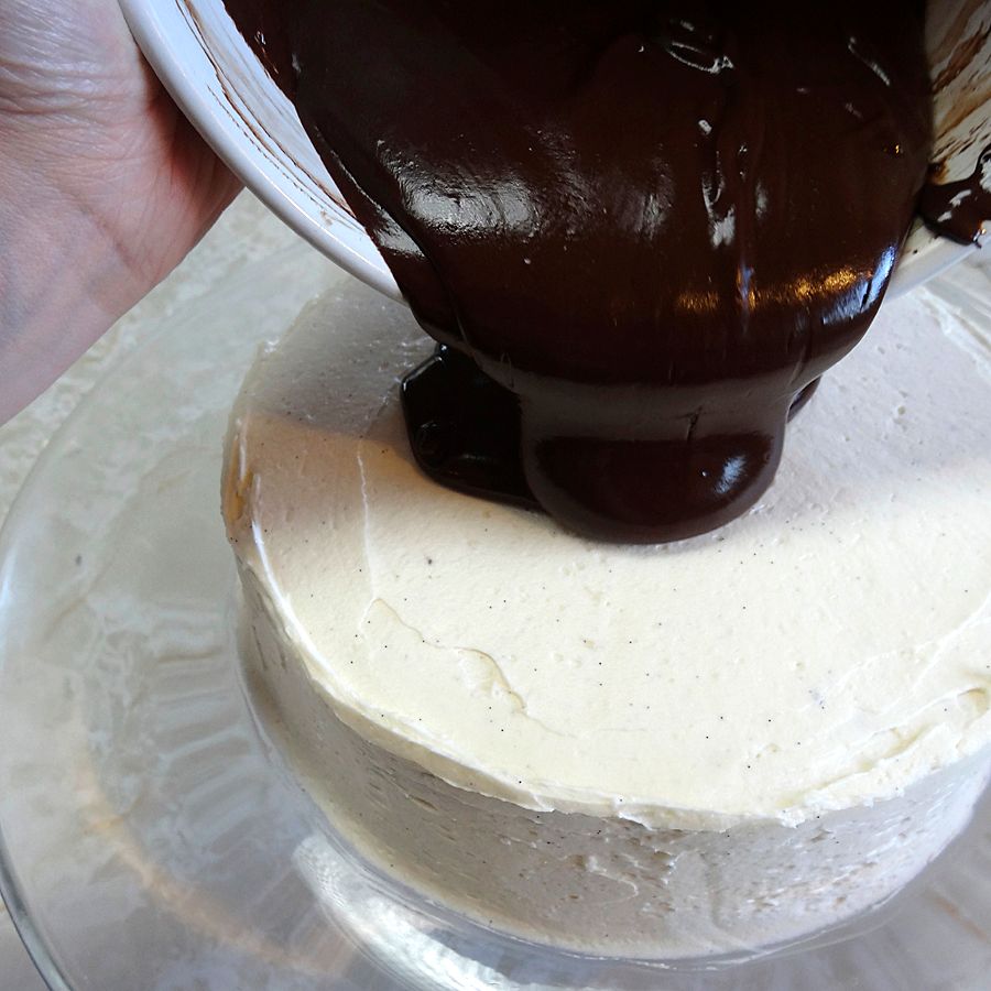 Pouring dark chocolate ganache on cake