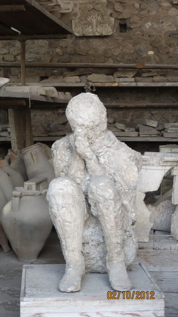 A body cast of someone trying to protect their face from the ash and debris.